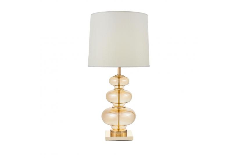 La lampada da tavolo o comodino BRISTON con paralume bianco un mix di tre materiali vetro dorato, metallo e tessuto ignifugo.
