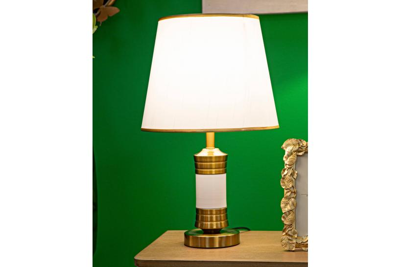 Lampada da tavolo in metallo dorato con elegante decorazione bianca e con base rotonda Lampada da tavolo in metallo dorato con elegante decorazione bianca e con base rotonda
